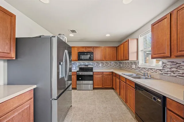 a kitchen with stainless steel appliances granite countertop refrigerator sink and stove