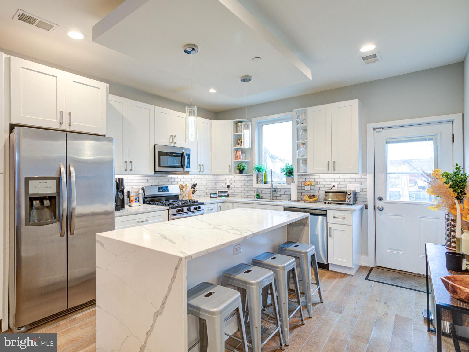 2639 Jasper Street Philadelphia, PA 19125 - Photo 3 of 23 a kitchen with a refrigerator a sink a stove a microwave a center island and cabinets