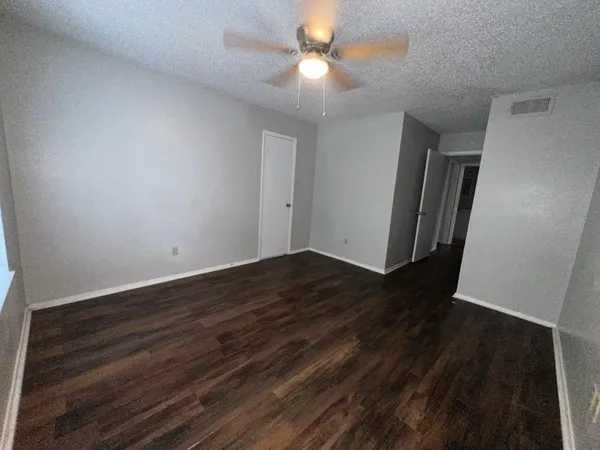 a view of a room with wooden floor and a ceiling fan