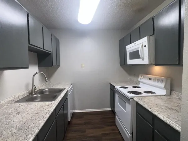 a kitchen with stainless steel appliances granite countertop a sink stove and cabinets