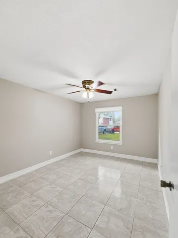 an empty room with windows and cabinet