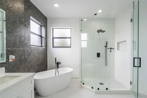 a white bath tub sitting next to a bathroom sink