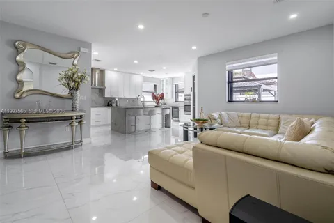 a living room with furniture and kitchen view