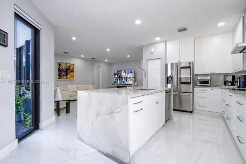 a kitchen with stainless steel appliances a refrigerator sink and cabinets