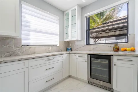 a kitchen with granite countertop white cabinets and window