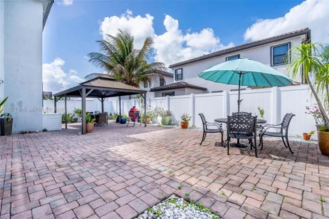 a view of a patio with a table and chairs under an umbrella