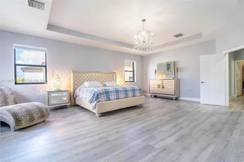 a spacious bedroom with a bed and a chandelier