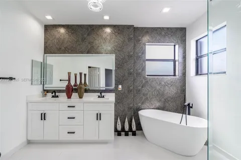 a bathroom with a bathtub sink and mirror