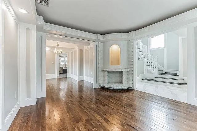 a view of a livingroom with wooden floor and a fireplace