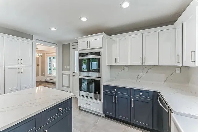 a kitchen with kitchen island granite countertop white cabinets and white appliances