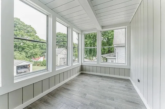 an empty room with wooden floor and windows
