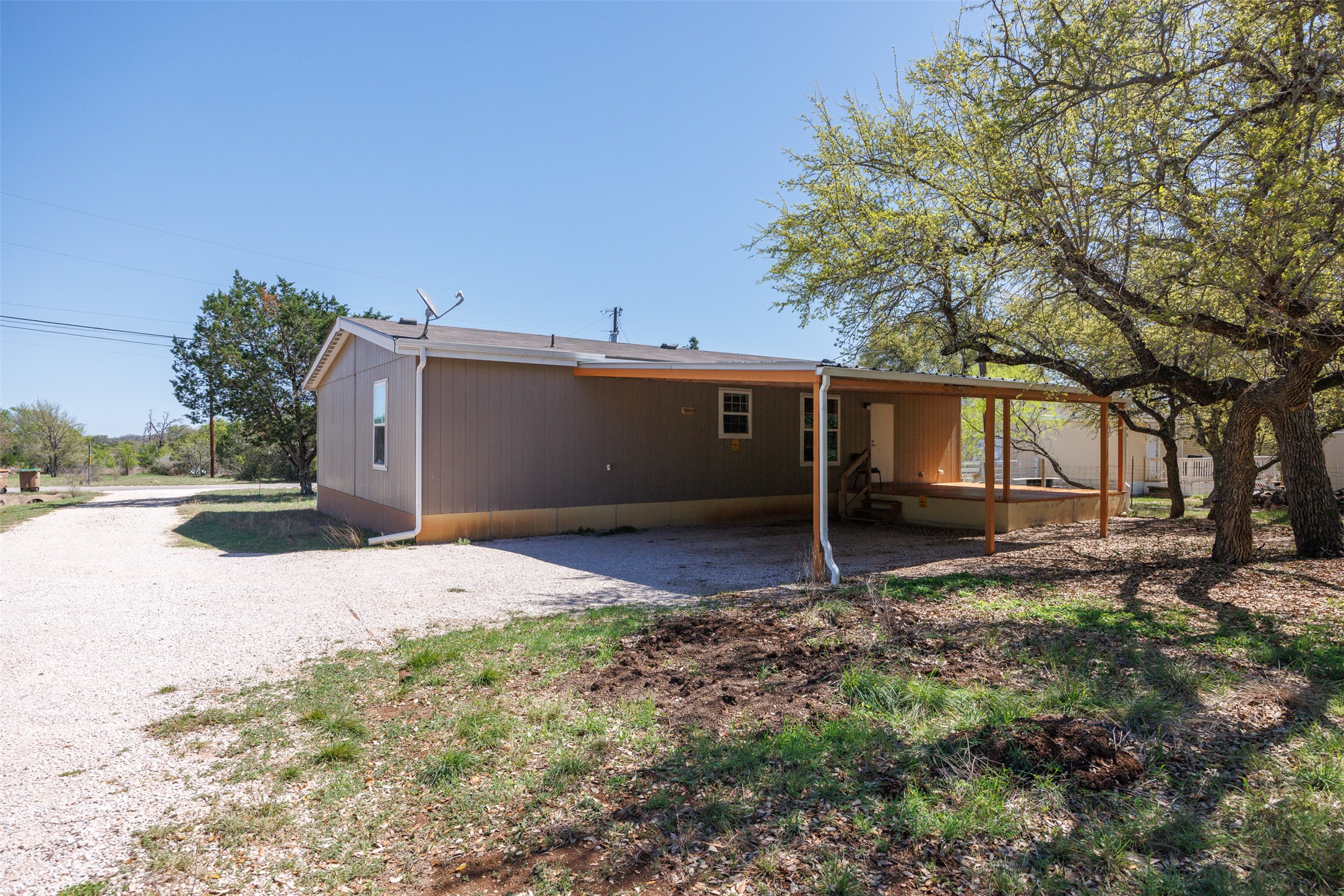 103 Spring View Drive Johnson City, TX 78636 - Photo 17 of 31 Rear view of property with an attached carport and gravel driveway