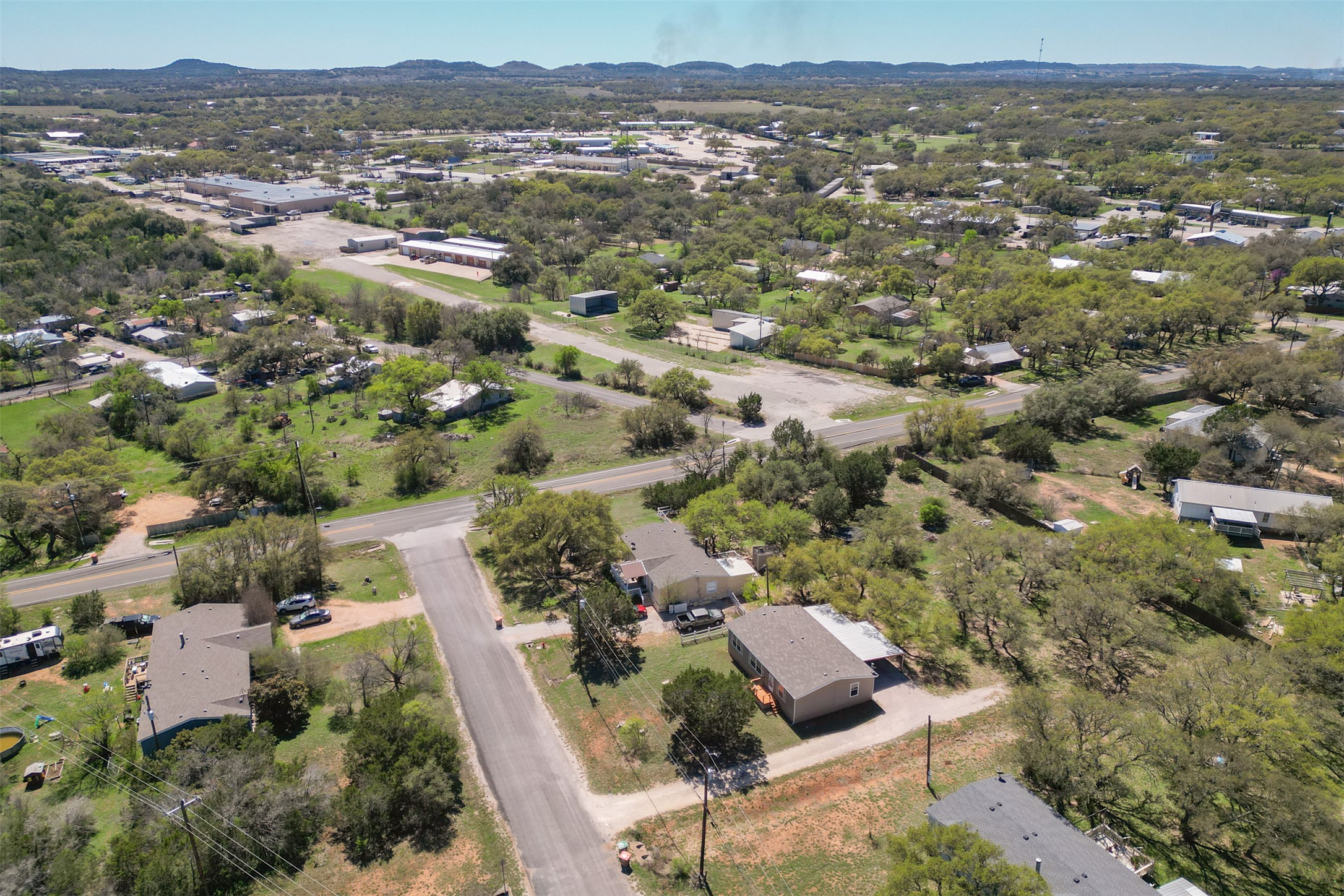 103 Spring View Drive Johnson City, TX 78636 - Photo 25 of 31 Aerial view of property and surrounding area featuring a mountainous background and nearby suburban area