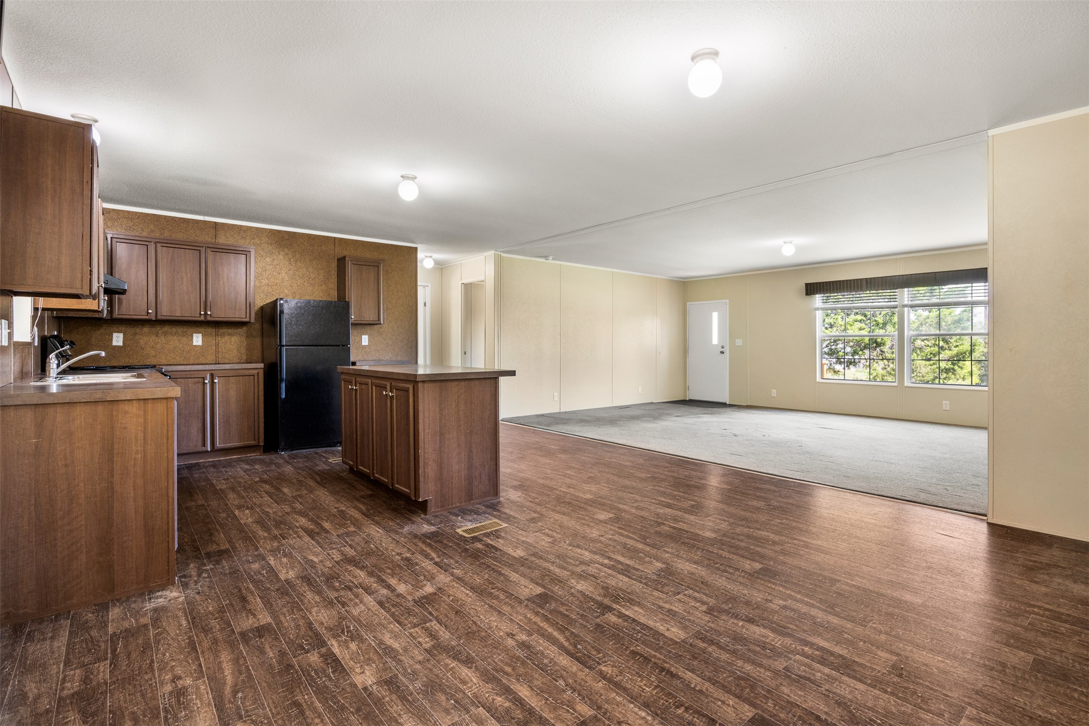 103 Spring View Drive Johnson City, TX 78636 - Photo 29 of 31 Kitchen with open floor plan, freestanding refrigerator, a kitchen island, ornamental molding, and decorative backsplash