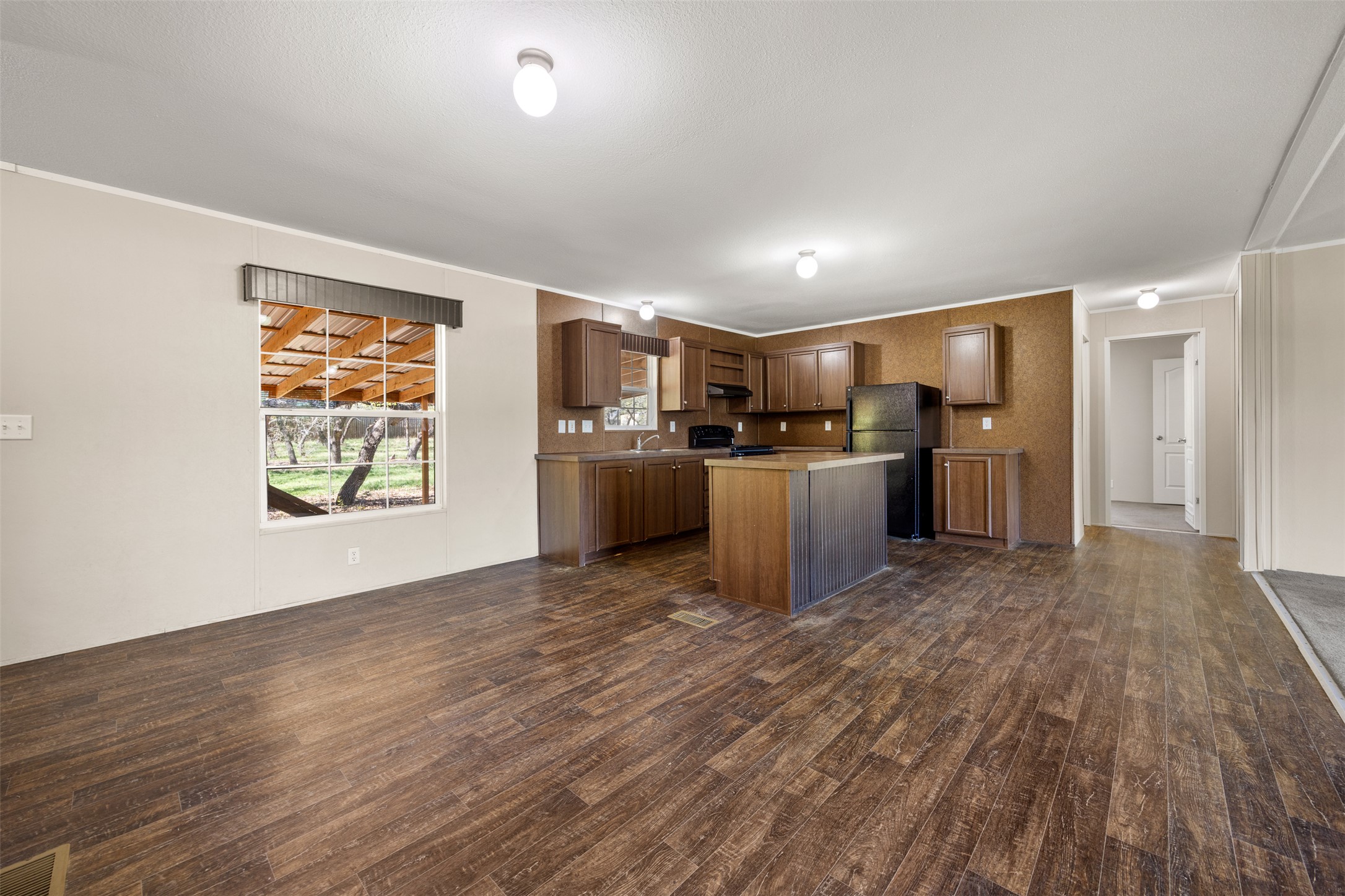 103 Spring View Drive Johnson City, TX 78636 - Photo 30 of 31 Kitchen featuring a kitchen island, light countertops, open floor plan, black appliances, and ornamental molding