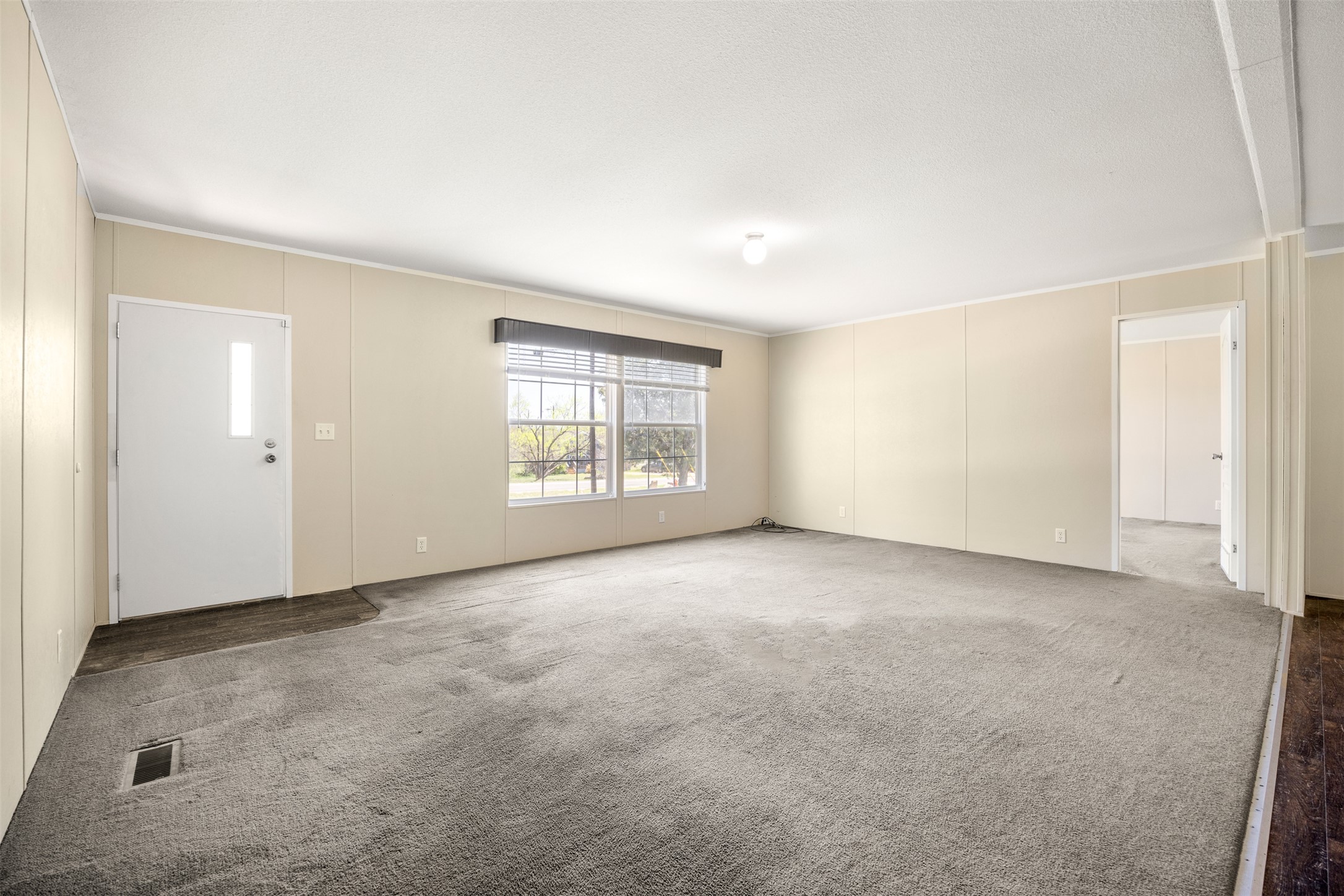 103 Spring View Drive Johnson City, TX 78636 - Photo 6 of 31 Unfurnished living room featuring carpet flooring and ornamental molding