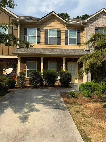 a front view of a house with yard and parking