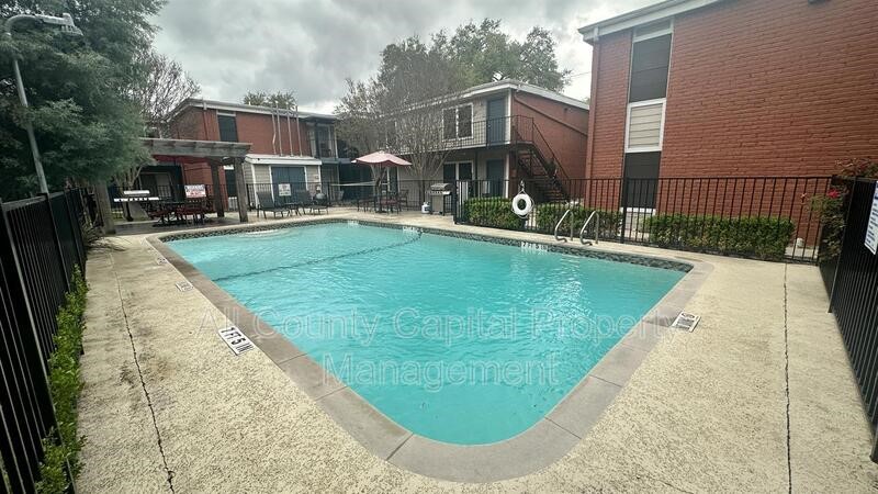 5426 Menchaca Road, Unit 214 Austin, TX 78745 - Photo 5 of 8 a view of a house with a swimming pool