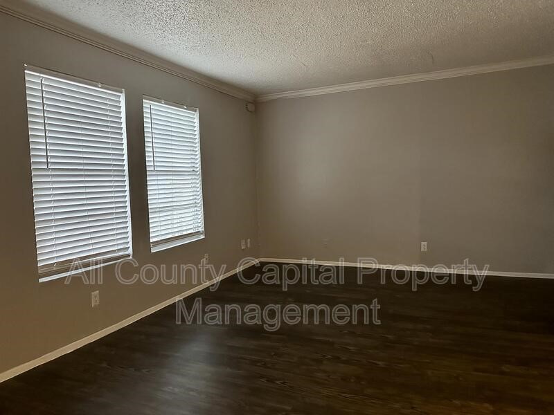 5426 Menchaca Road, Unit 214 Austin, TX 78745 - Photo 6 of 8 a view of an empty room with wooden floor and a window