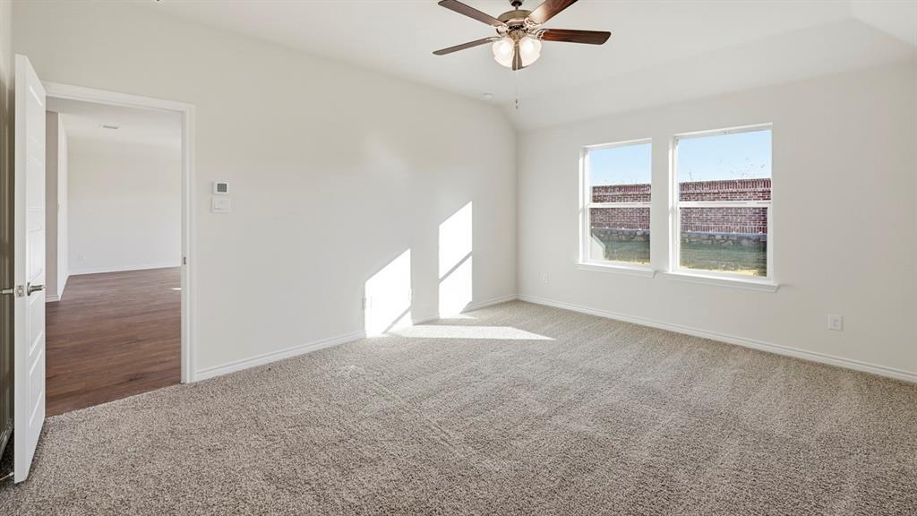 403 Flintlock Road Caddo Mills, TX 75135 - Photo 16 of 26 Carpeted empty room with lofted ceiling and a ceiling fan