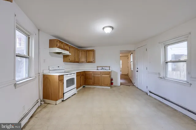 a view of a kitchen with wooden cabinet and a window