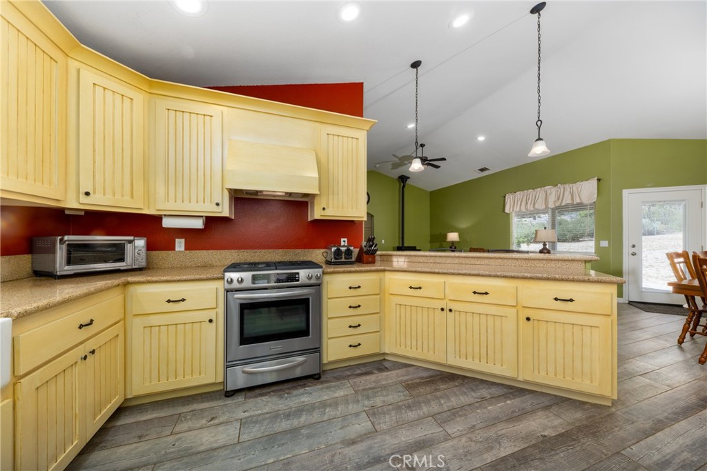 5935 Monte Vista Road Phelan, CA 92371 - Photo 16 of 58 a kitchen with stainless steel appliances granite countertop a stove a sink and white cabinets