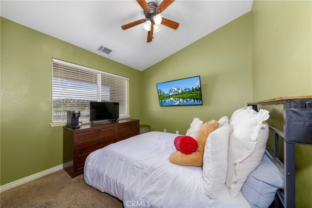 5935 Monte Vista Road Phelan, CA 92371 - Photo 25 of 58 a bedroom with a bed and a flat screen tv