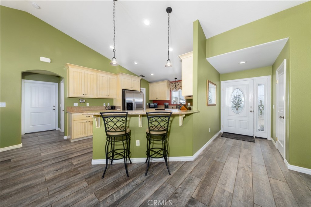 5935 Monte Vista Road Phelan, CA 92371 - Photo 28 of 58 a dining room with stainless steel appliances kitchen island furniture and wooden floor