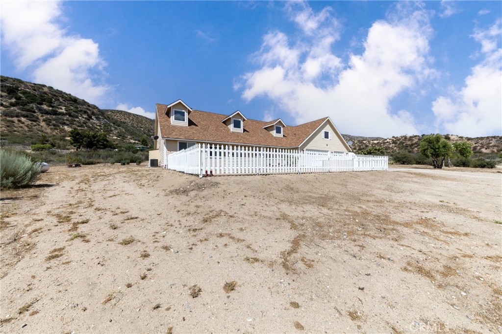 5935 Monte Vista Road Phelan, CA 92371 - Photo 5 of 58 a view of a dry yard with wooden fence