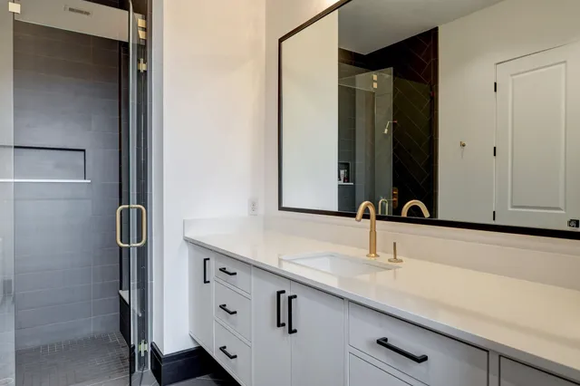 a bathroom with a double vanity sink a mirror and shower