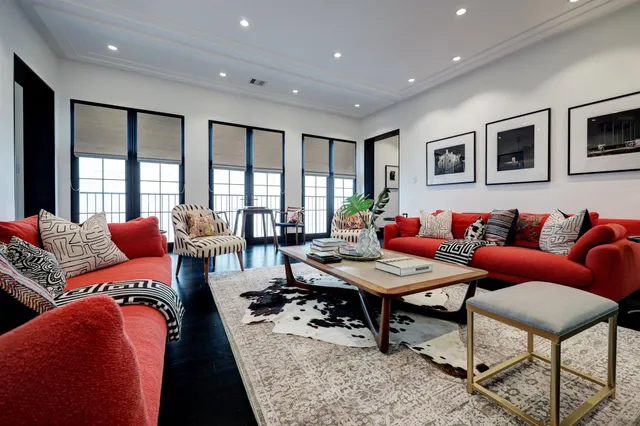 a living room with furniture kitchen view and a large window