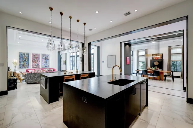 a kitchen with a counter top space a sink appliances and living room