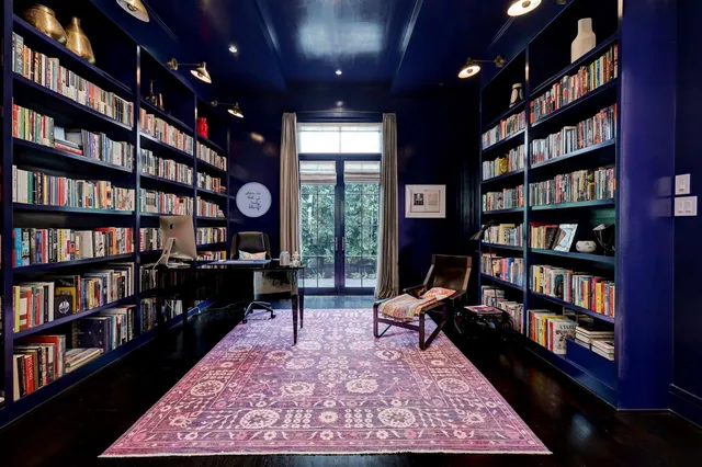 a living room with a book shelf and a book shelf