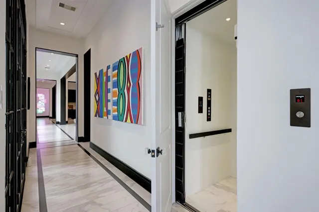 a view of a hallway with lots of frames on wall
