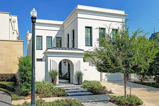 a view of a house with potted plants and large tree