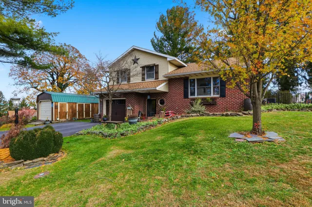 a view of a house with a yard and a tree
