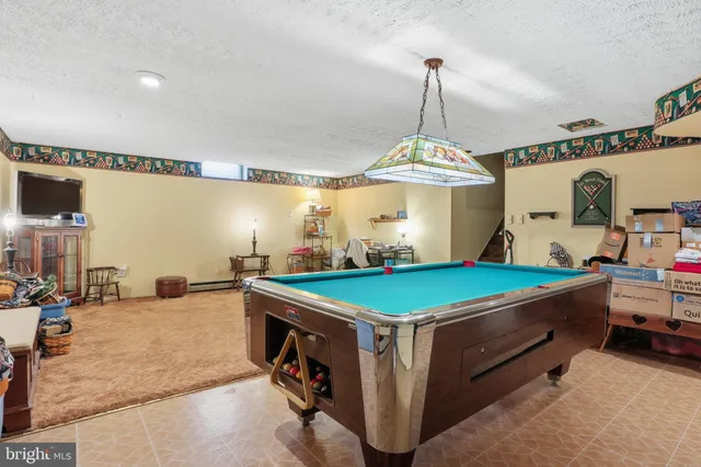 a room with pool table and windows