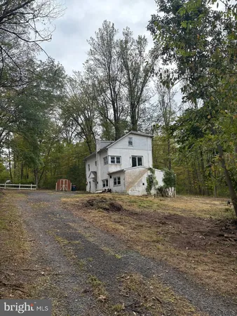 a view of a house with a large tree in front of it