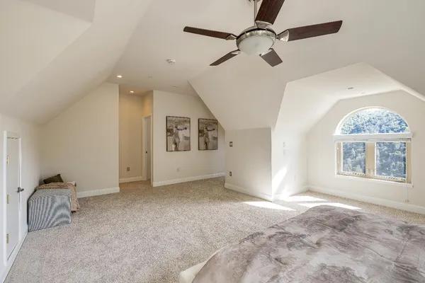 an empty room with a window and a fan