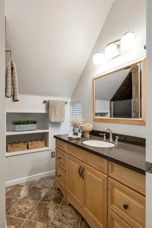 a kitchen with kitchen island granite countertop wooden floors and a view of living room