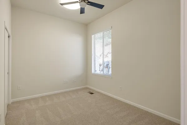 a view of a livingroom with a ceiling fan & a window