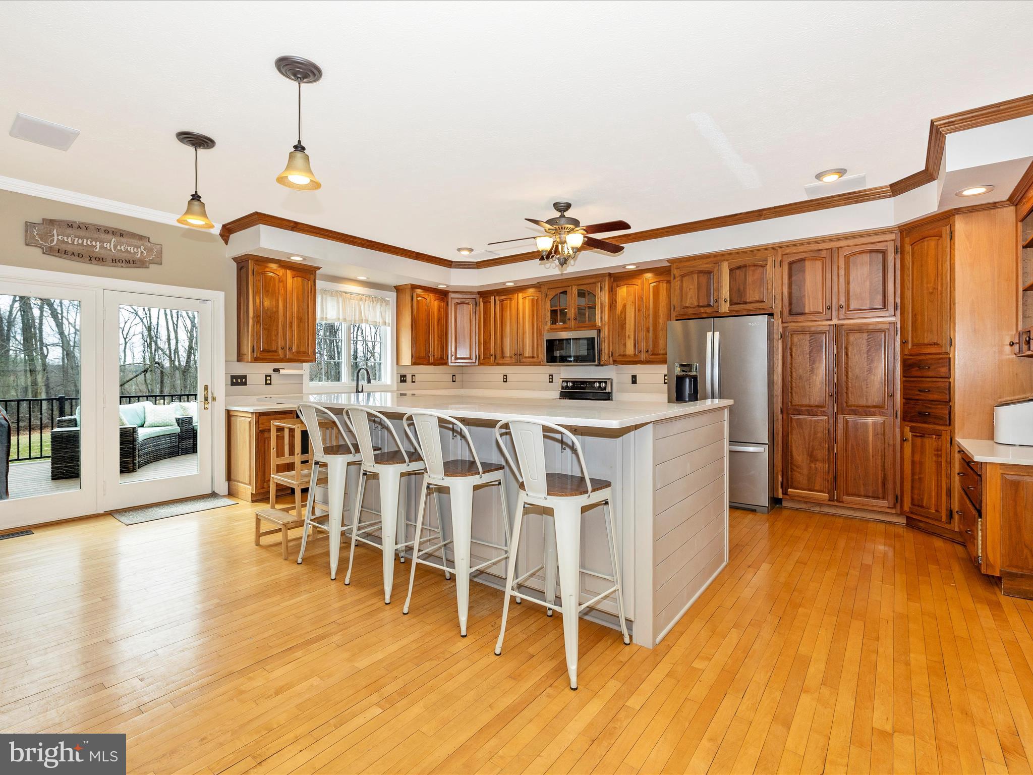 1345 Brehm Road Westminster, MD 21157 - Photo 22 of 131 a kitchen with stainless steel appliances kitchen island granite countertop a stove a refrigerator a dining table and chairs with wooden floor