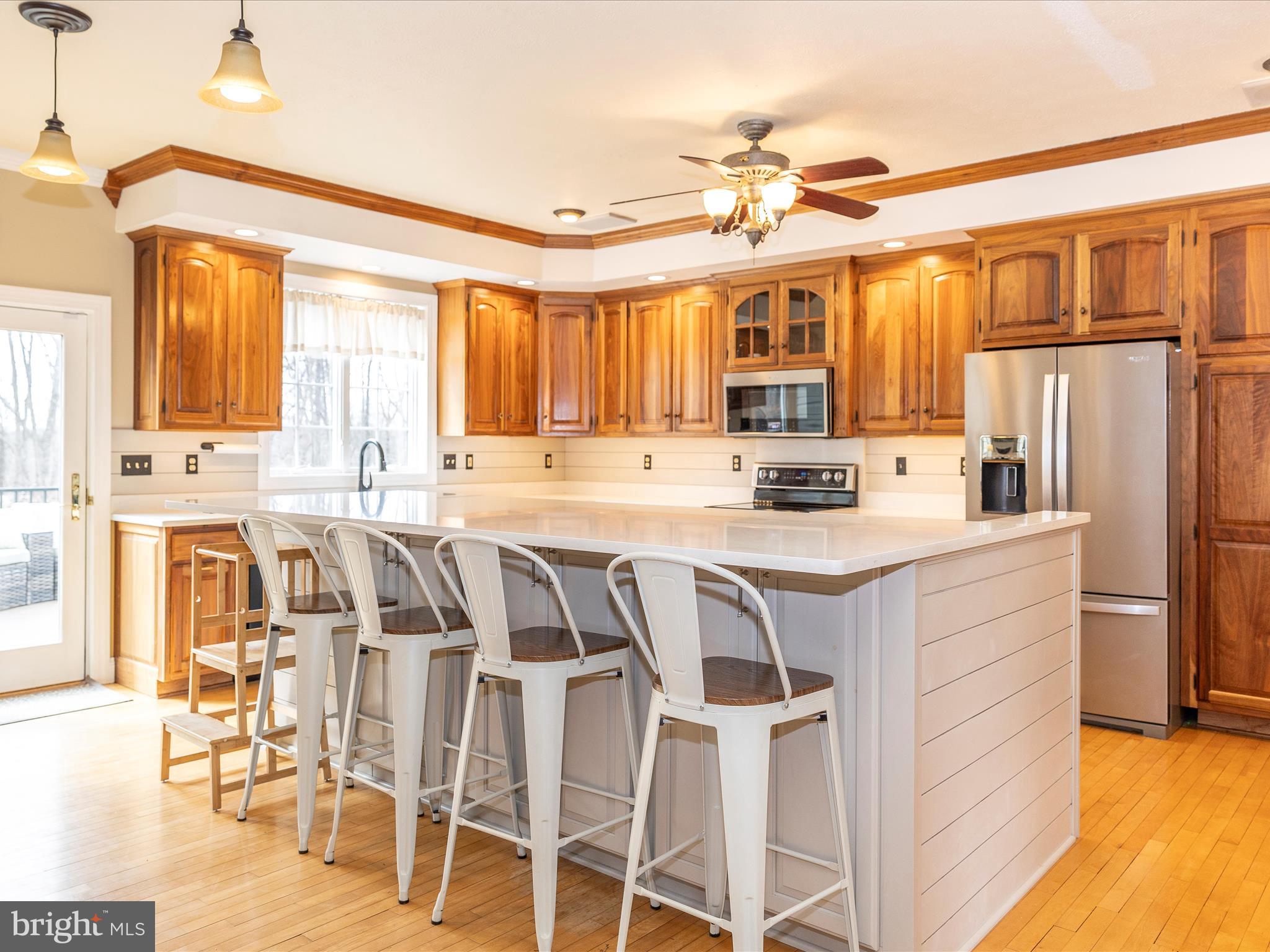 1345 Brehm Road Westminster, MD 21157 - Photo 23 of 131 a kitchen with stainless steel appliances granite countertop a refrigerator a stove and a dining table with wooden floor