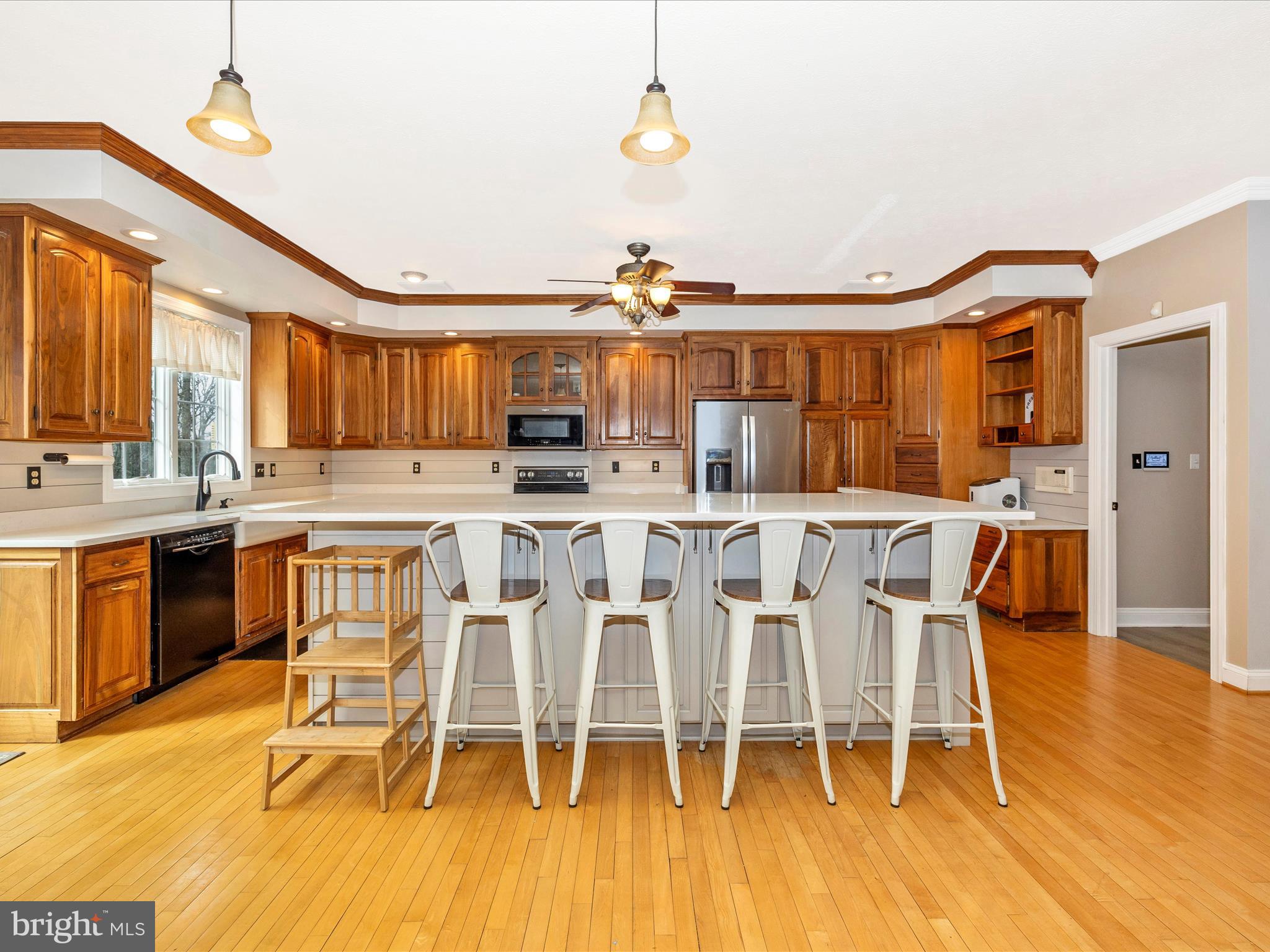1345 Brehm Road Westminster, MD 21157 - Photo 24 of 131 a kitchen with stainless steel appliances kitchen island granite countertop a table chairs and a wooden floor