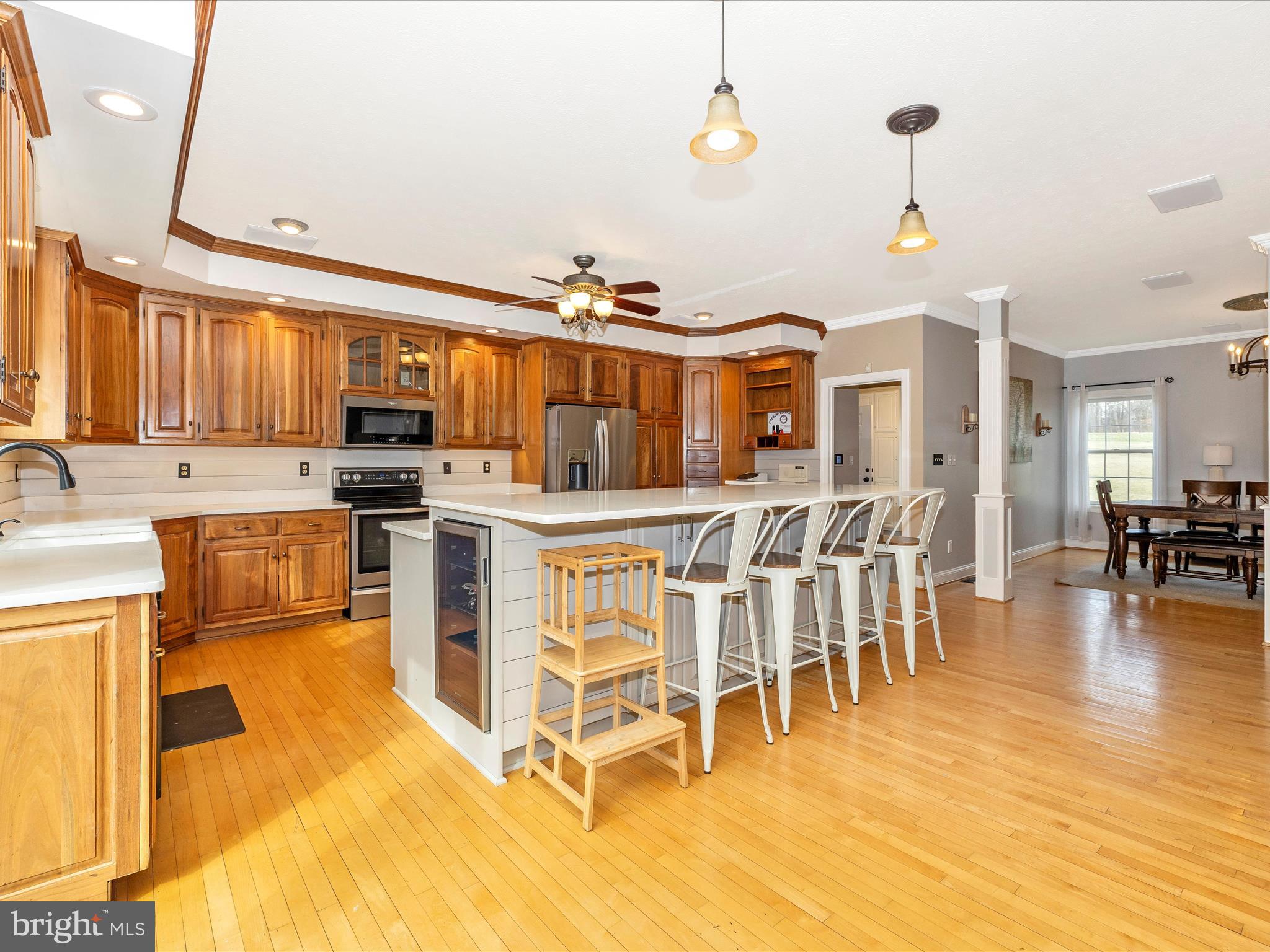 1345 Brehm Road Westminster, MD 21157 - Photo 25 of 131 a kitchen with stainless steel appliances granite countertop a stove top oven a sink a dining table and chairs with wooden floor