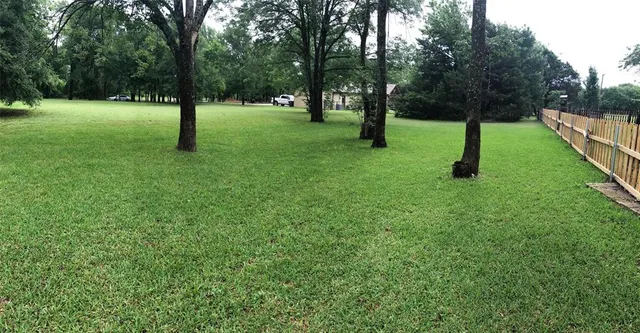 a view of green field with trees in the background