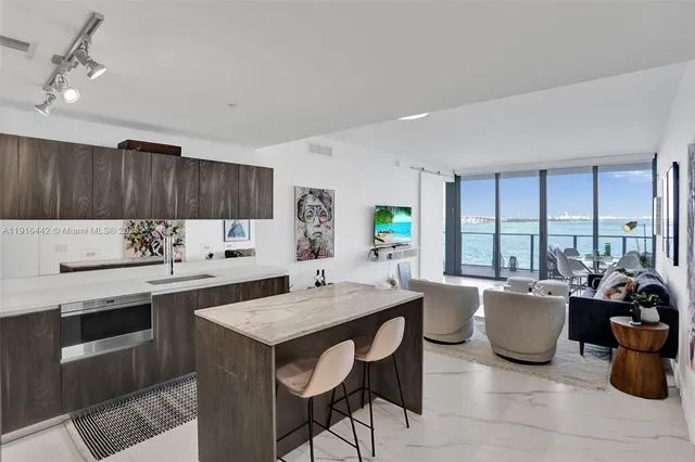 a kitchen with a dining table chairs and white appliances