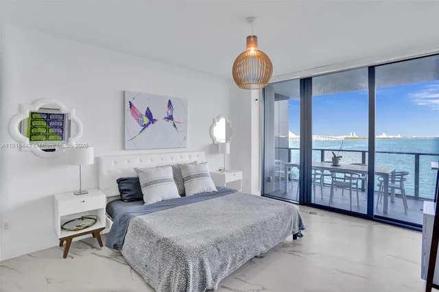 a bedroom with a large bed and a chandelier