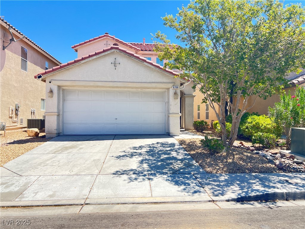 Mediterranean / spanish-style house with driveway, stucco siding, a garage, and a tile roof