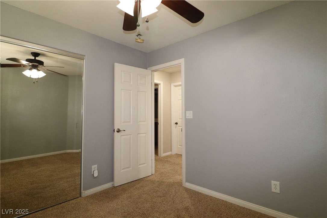 8708 Palomino Ranch Street Las Vegas, NV 89131 - Photo 11 of 19 Unfurnished bedroom featuring light carpet, a closet, and a ceiling fan